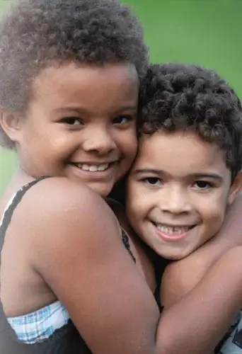 Two young children hugging and having fun.