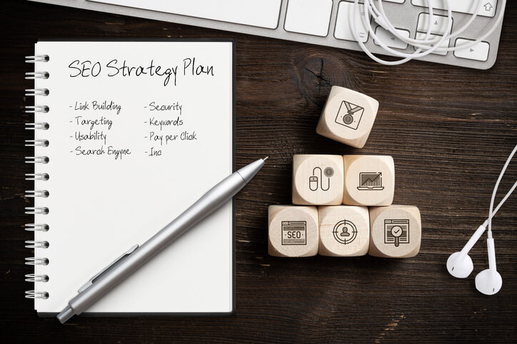 SEO strategy with components for successful marketing as icons on cubes on wooden background