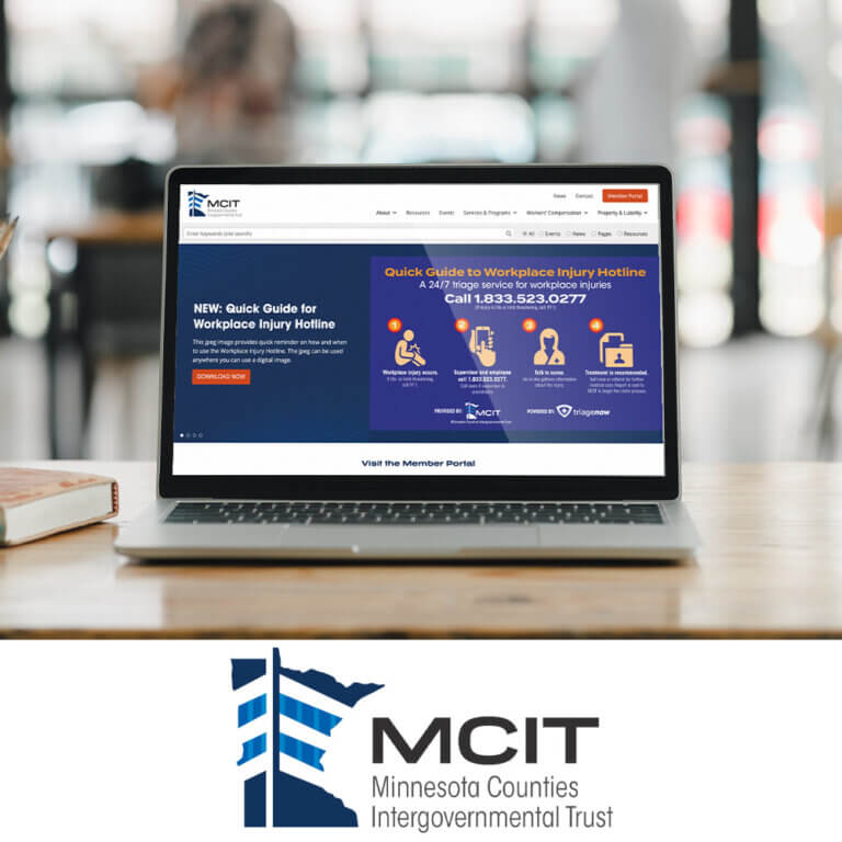 MCIT's website on a laptop screen on a wooden table with the logo underneath.