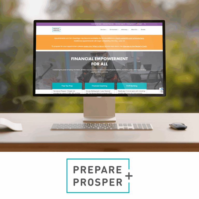 A computer monitor on a wooden desk displays the Prepare + Prosper website homepage, which features a banner stating "Financial Empowerment for All" and service options like Free Tax Prep, Financial Coaching, and FAIR Banking. Below the image is the Prepare + Prosper logo, which includes the organization's name in uppercase letters enclosed in a teal outlined rectangle with a plus sign. The background shows a softly blurred natural setting through a window.