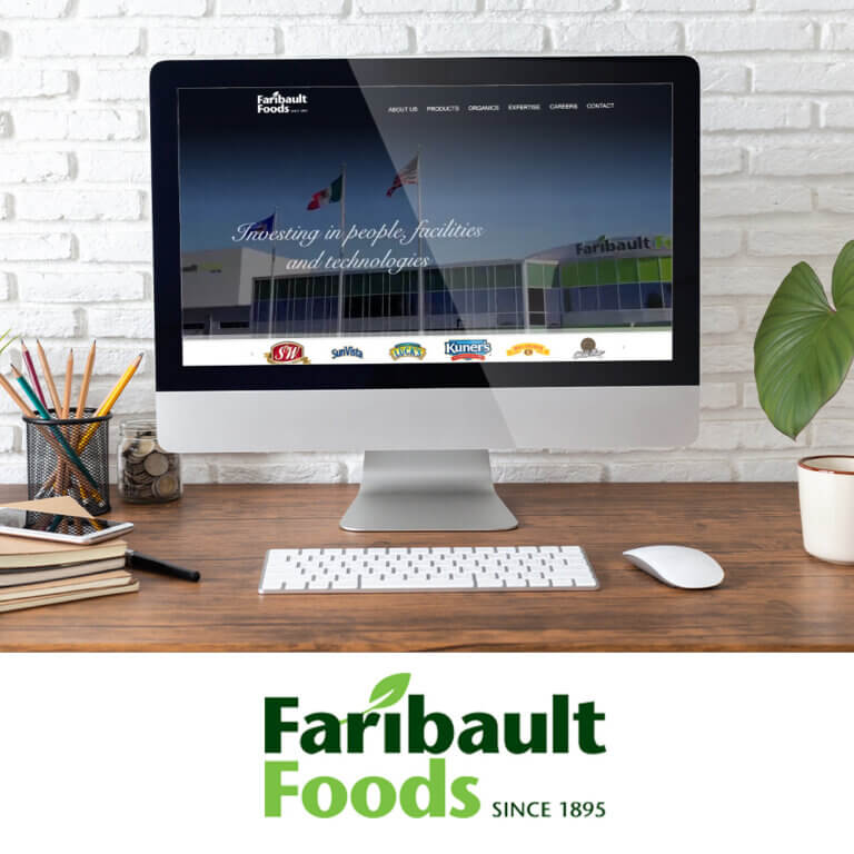 Desktop computer displaying the redesigned Faribault Foods website with a modern layout showcasing the company’s facility and brand logos. The Faribault Foods logo with a green leaf and “Since 1895” tagline is shown below.