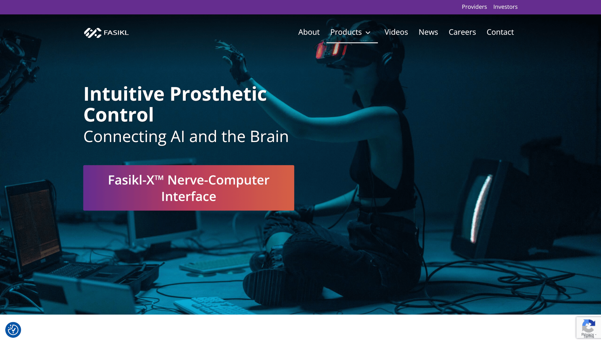 Fasikl website homepage showing a person wearing a VR headset and motion-tracking gloves reaching out in a dimly lit, futuristic lab environment with cables and monitors around them. The page headline reads “Intuitive Prosthetic Control — Connecting AI and the Brain,” with a button labeled “Fasikl-X™ Nerve-Computer Interface.” The navigation bar includes links for About, Products, Videos, News, Careers, and Contact, on a purple and black interface.