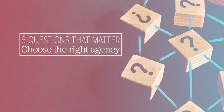 Wooden blocks with question marks connected by lines, with the text “6 QUESTIONS THAT MATTER. Choose the right agency.”